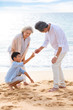 © Blue Jean Images - Grandparent and grandson having fun on beach