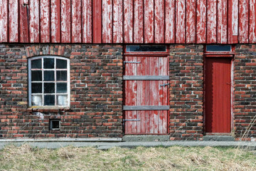 Red door and window on brick wall on Frøya an island outside Trondheim in Norway