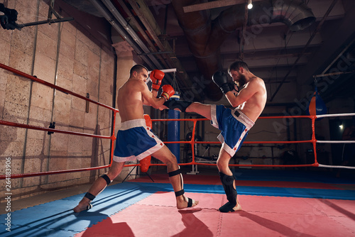 Dekoracja na wymiar  zawodnik-cwiczacy-kickboxing-ze-sparingpartnerem-walczacy-na-ringu-o-zdrowie