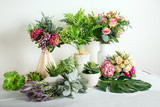 Fototapeta  - Various artificial flowers, bouquets in vases, succulents