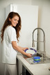 © Samo Trebizan - Beautiful young woman wash dishes in the kictchen