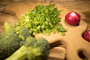 Wall Mural - broccoli, chopped green onions, radishes on the table