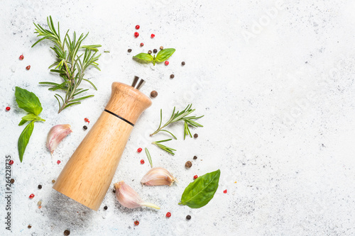 Fotografía Pepper mill with fresh herbs on white.