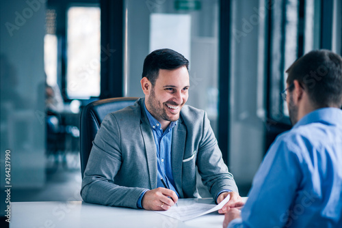 Handsome male client signing document on a meeting with real estate agent Poster Mural XXL