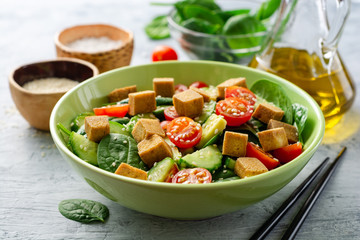 Wall Mural - Vegan salad with spinach, cucumber, tomatoes, avocado, fried tofu and sesame. Selective focus.