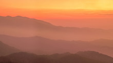 Mountain View Evening Of Top Hill Around With Soft Fog With Yellow And Red Sun Light In The Sky Background, Sunset At Huai Nam Dang National Park, Chiang Mai, Thailand.