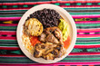 Lunch Plate of Grilled Meat, Beans, Rice, Potato in Guatemala with Decorative Tablecloth (Close-up)