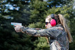 © Daniel Teetor - A woman shooting a handgun and the ejected cartridge case in the air.