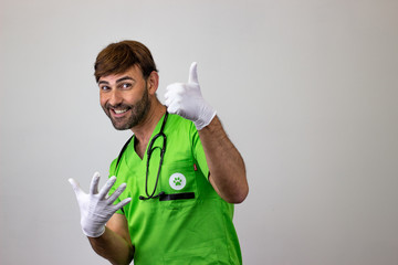 Wall Mural - Portrait of male veterinary doctor in green uniform with brown hair holding up six fingers, facing forwards and looking at the horizon. Isolated on white background.