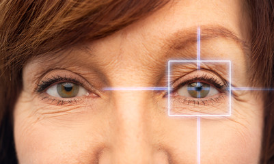 Wall Mural - vision, eye surgery and security concept - eyes of senior woman with laser light