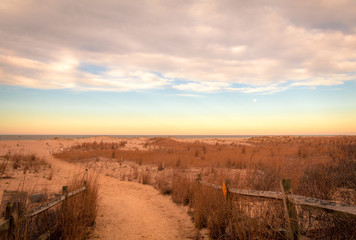 Sandy path leads to ocean in Cape May, NJ, at sunrise