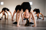 Group of fit happy children exercising ballet and dancing in studio together