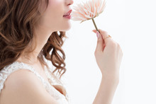 白背景に茶髪の巻き髪をした綺麗な女性が花をもって上を向いている姿キャバクラモデル美人