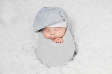 Wall Mural - newborn baby lies in a beautiful hat