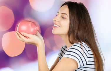 Canvas Print - Young woman with a piggy bank