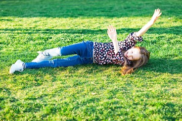 Child rolling down hill in grass