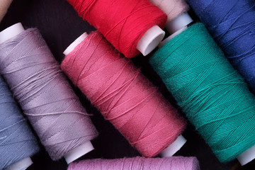 Top view close up of scattered colorful cotton thread coils