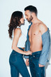 © LIGHTFIELD STUDIOS - sensual young woman unzipping jeans on boyfriend on grey