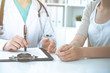 © rogerphoto - Doctor and patient are discussing something in clinic, just hands at the desk. Medicine and best service concept