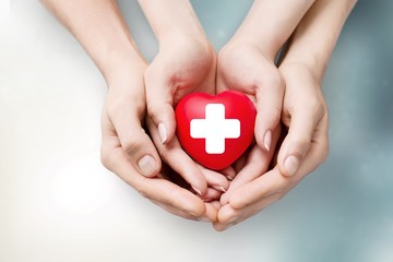 Wall Mural - Man and woman holding red heart in hands isolated