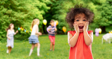 Poster - childhood, expressions and emotions concept - surprised or scared little african american girl screaming over birthday party at summer park background