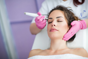 Wall Mural - beautiful woman in professional beauty salon during photo rejuvenation procedure