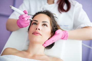 Wall Mural - beautiful woman in professional beauty salon during photo rejuvenation procedure