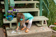 © Adam Hester - A preschool aged girl drawing with chalk outdoors on the cement.