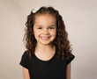© ShannonK - Biracial preschooler with curly brown hair isolated on brown background