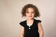 © ShannonK - Smiling toddler with brown curly hair isolated on beige background
