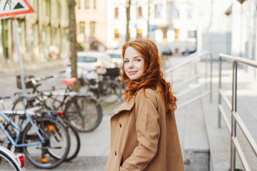 Wall Mural - Young redhead girl in the street, looking back