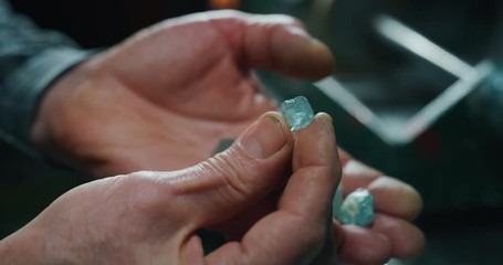 Wall Mural - Slow motion of experienced goldsmith sorting high quality aquamarine stones, selecting them to make precious jewels in workshop. Shot in 8K. Concept of jewelry, luxury, goldsmith, diamonds,brilliance