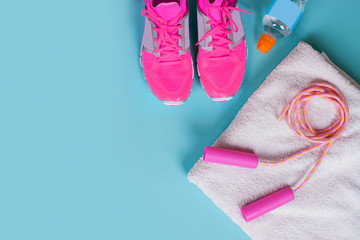 sports flat lay with water, sneakers on blue background.