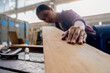 © MIND AND I - Carpenter working with equipment on wooden table in carpentry shop. woman works in a carpentry shop.