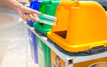 Man Hand Throwing Plastic In Recycling Bin To Help Environmental Protection And Waste Separation Reduce Global Warming.