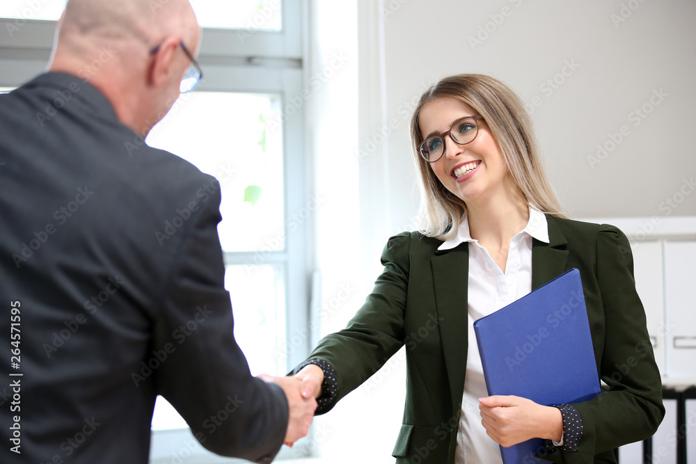 Junge Frau wird zu einem Vorstellungsgespräch begrüßt