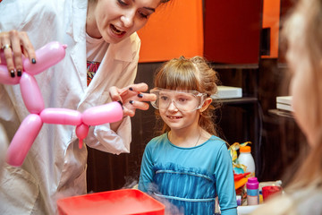 Chemical show for kids. Professor carried out chemical experiments with liquid nitrogen on Birthday little girl.