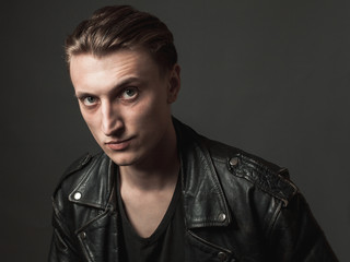 Portrait of the serious young man in leather jacket