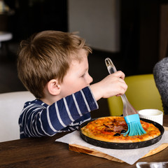 Wall Mural - child and adult make pizza for dinner, hands add sausage and tomatoes, copy space and lifestyle, top point of view