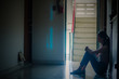 © TeTe Song - Silhouette of girl sitting alone,Sad and Serious women sitting hug his knee alone of close condo., Dramatic moment. with copy space