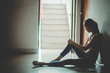 © TeTe Song - Silhouette of girl sitting alone in the dark,Sad and Serious women sitting hug his knee alone of old condo, Domestic violence, family problems, Stress, violence, The concept of depression and suicide.