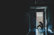 © TeTe Song - Silhouette of girl sitting alone in the dark,Sad and Serious women sitting hug his knee alone of old condo, Domestic violence, family problems, Stress, violence, The concept of depression and suicide.