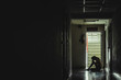 © TeTe Song - Silhouette of girl sitting alone in the dark,Sad and Serious women sitting hug his knee alone of old condo, Domestic violence, family problems, Stress, violence, The concept of depression and suicide.