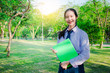 © TeTe Song - Portrait of thai high school student uniform teen beautiful girl happy and relax holds notebooks in his hands at the park.