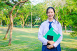 © TeTe Song - Portrait of thai high school student uniform teen beautiful girl happy and relax holds notebooks in his hands at the park.