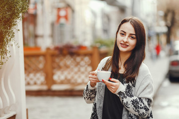 The girl on the street. Woman and coffee. Beautiful girl resting