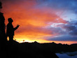 © Payllik - Black silhouette of a man smoking a cigar against the background of a bright contrasting sunset in the mountains in the Alps.