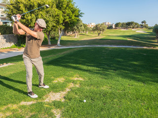 athletic and attractive man playing golf on a sunny day