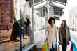 © Westend61 - Two happy women with shopping bags walking in the city