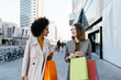 © Westend61 - Two happy women with shopping bags walking in the city